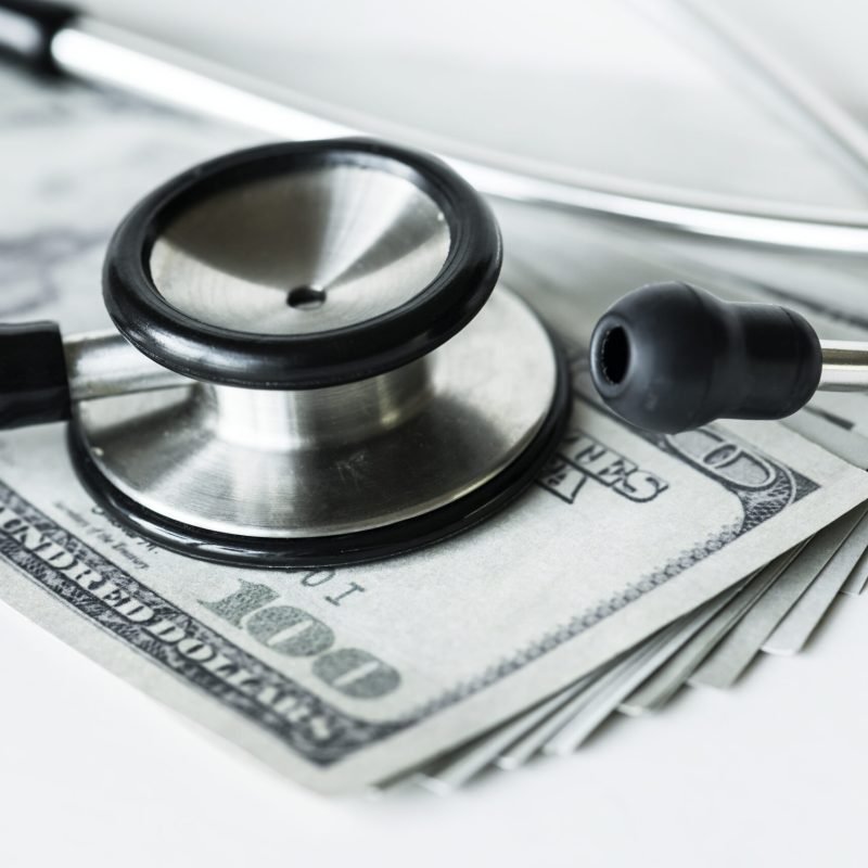 closeup-cash-stethoscope-healthcare-expenses-concept