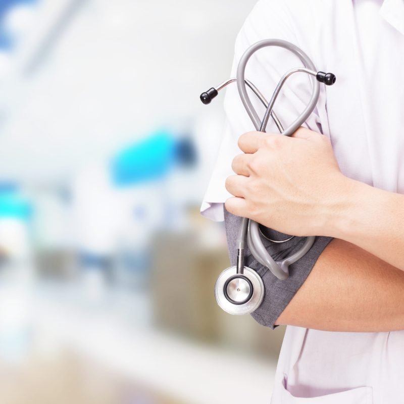 Doctor with a stethoscope in the hands and hospital background.