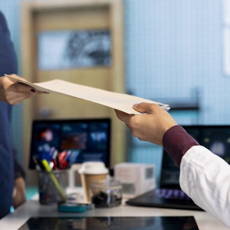 Indian healthcare professional sharing medical expertise with a patient in office, examining x ray and MRI scans results and focusing on disease recovery. Diagnostic report in a meeting.